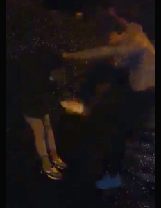 The victim is held down by the hood as the thug kicks her in the face.